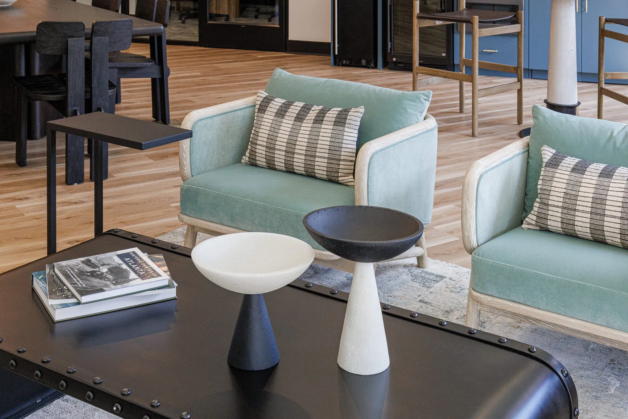 Multifamily interior detail: mint velvet armchairs around a black riveted coffee table, interior design by Banko Design at The Hawkins, Chamblee, Georgia