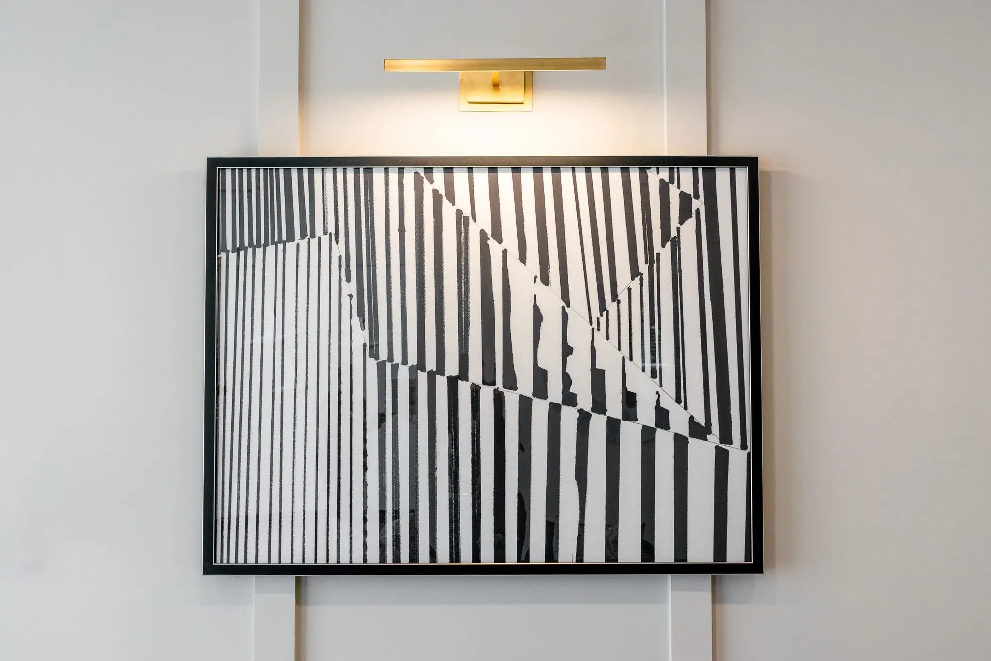 Multifamily amenity leasing area with a black and white stripe abstract centred between white panel mouldings
