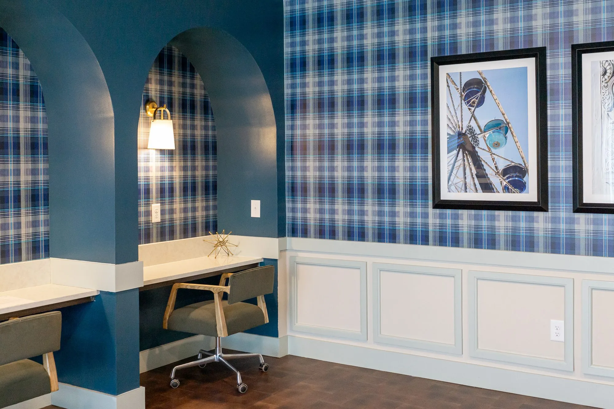 Multifamily amenity arched desk niches with two framed photographs above white wainscot
