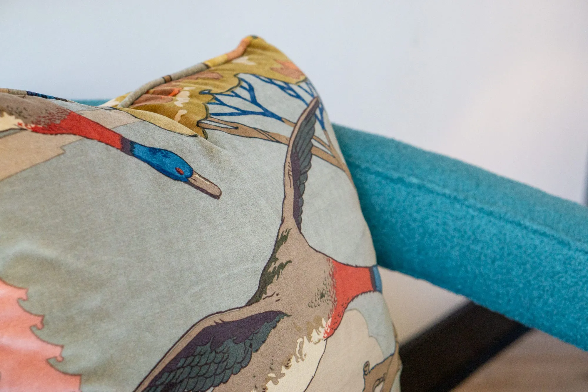 Multifamily amenity interior detail: duck print pillow on a teal armchair