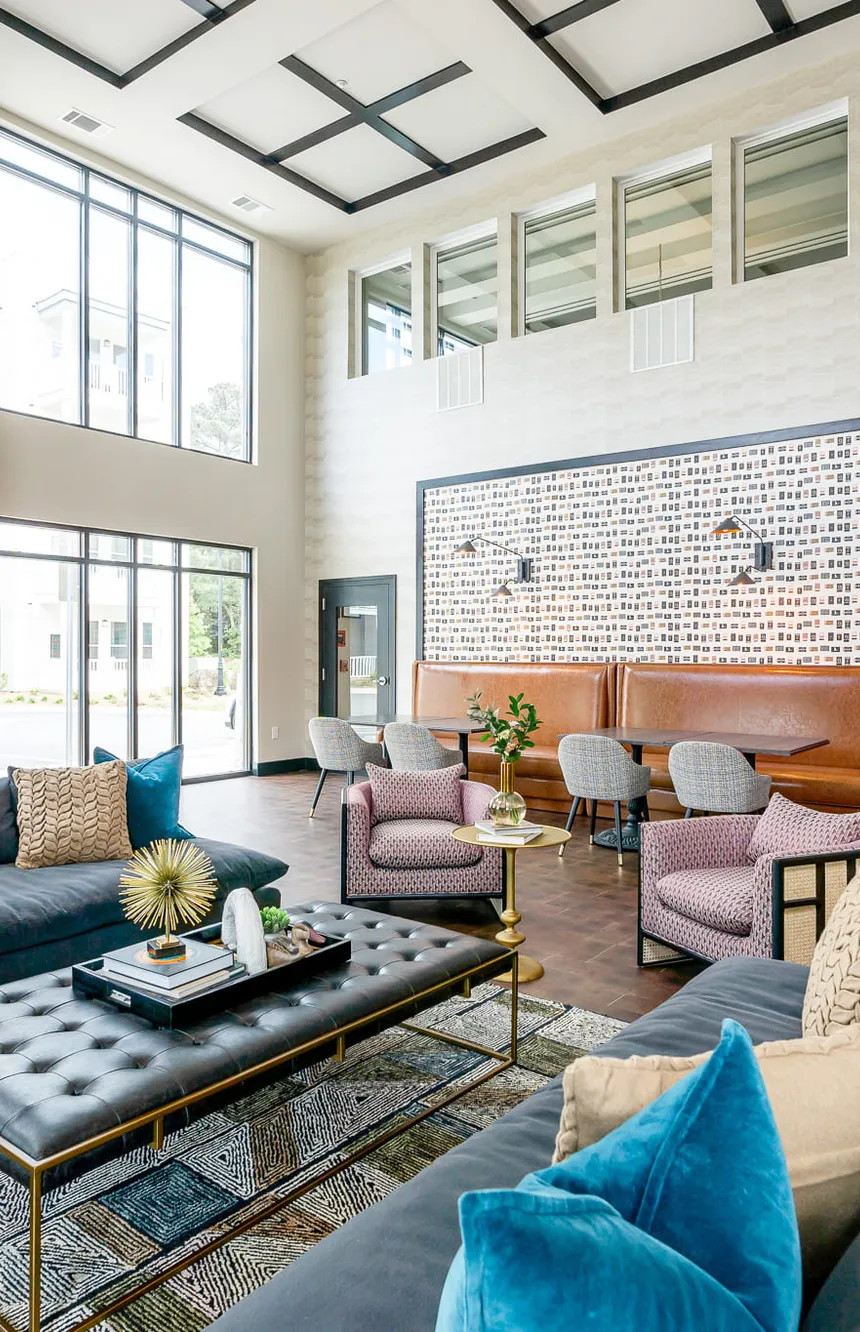 Multifamily amenity double height clubroom with a black coffered ceiling and navy sofas, interior design by Banko Design at The Mallory, Raleigh, North Carolina