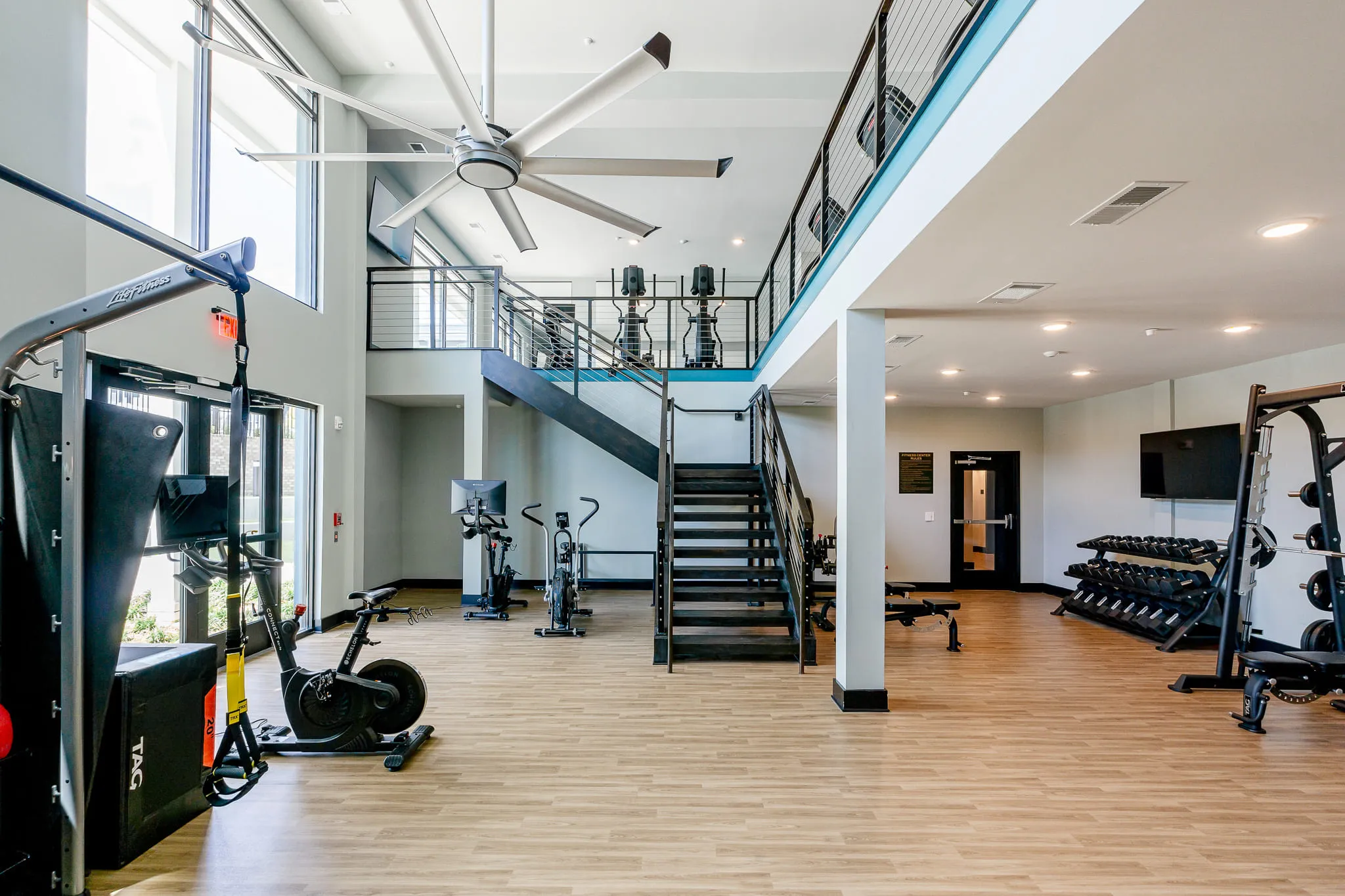 Multifamily amenity fitness center with cardio equipment and free weights, interior design by Banko Design at The Mallory, Raleigh, North Carolina