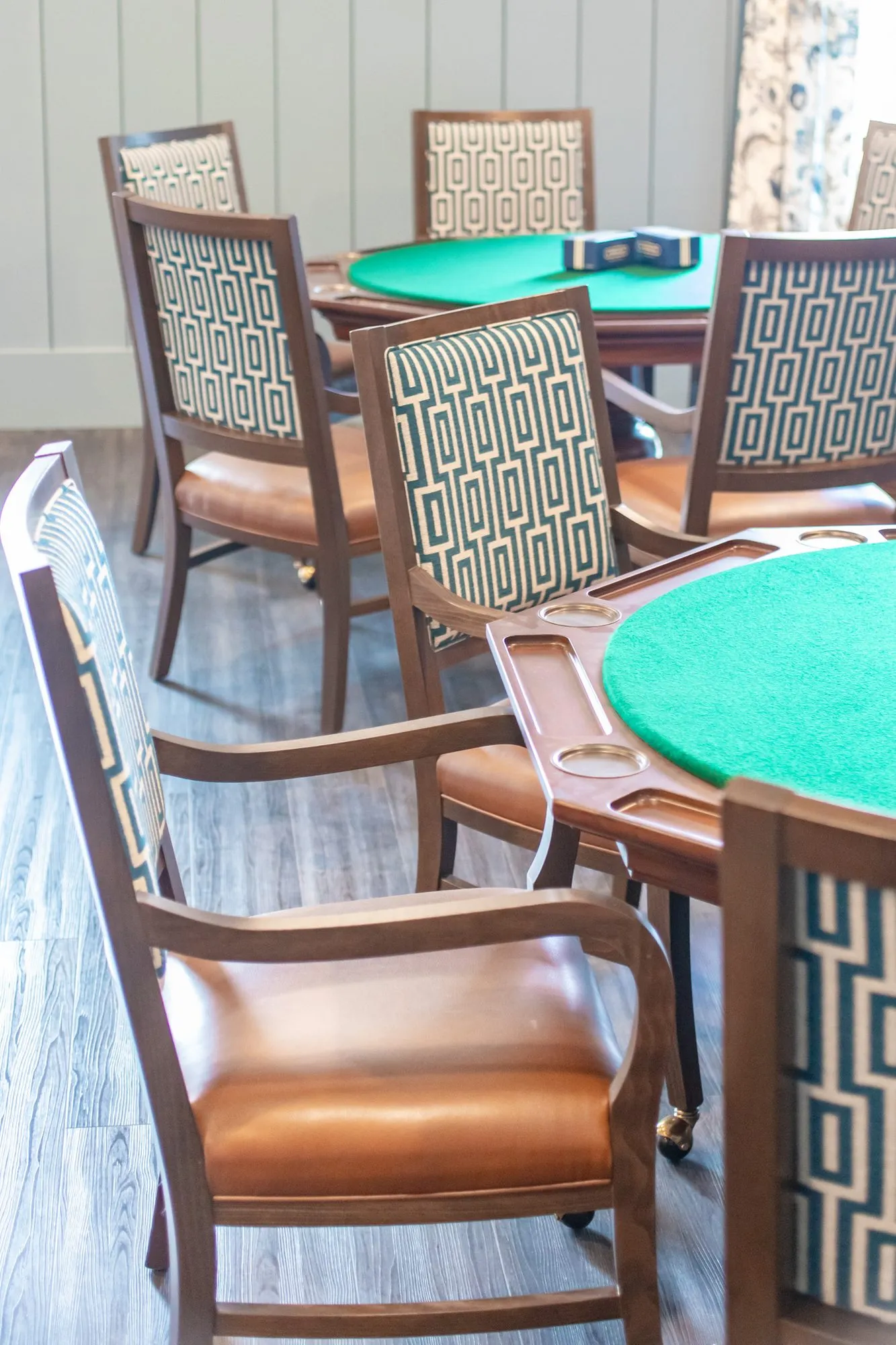 Senior living card room with green felt card tables and Greek key back chairs with leather seats