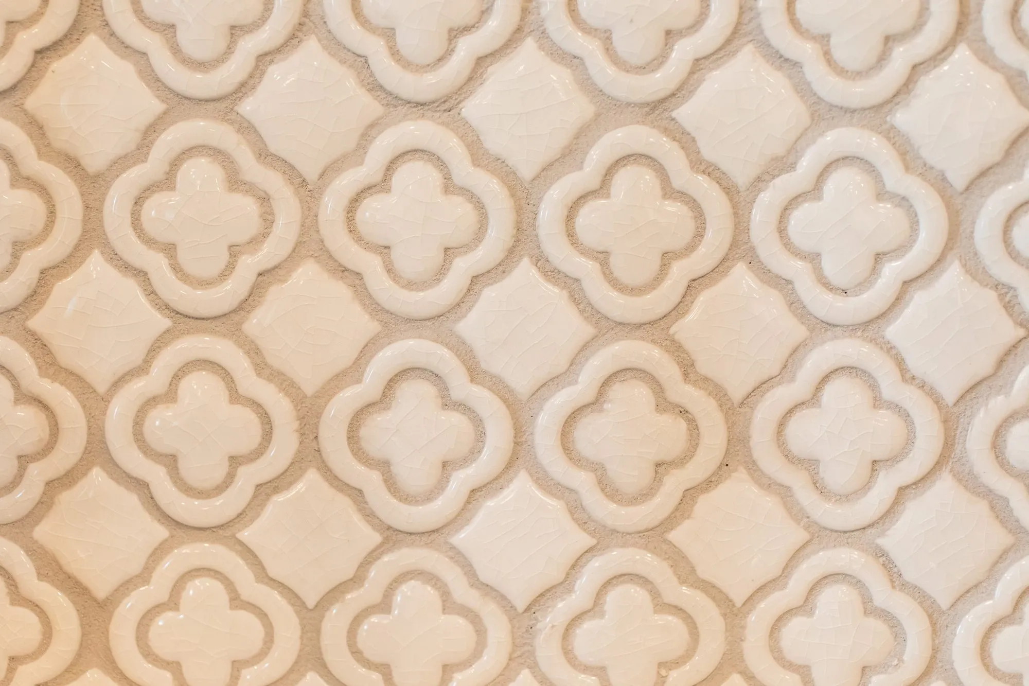 Senior living interior detail: white glazed quatrefoil relief tile