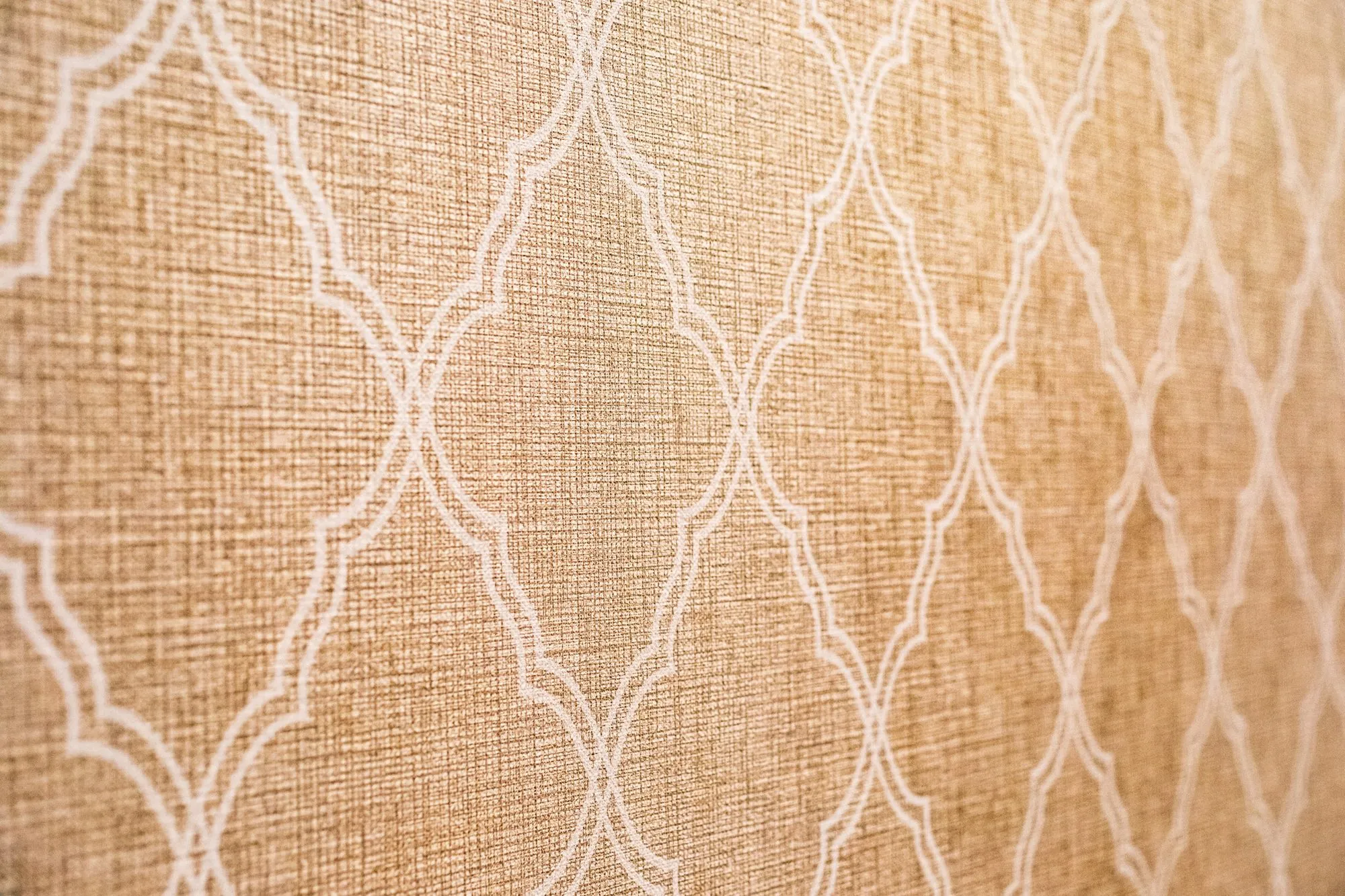 Senior living interior detail: tan textured wallcovering with a white trellis pattern