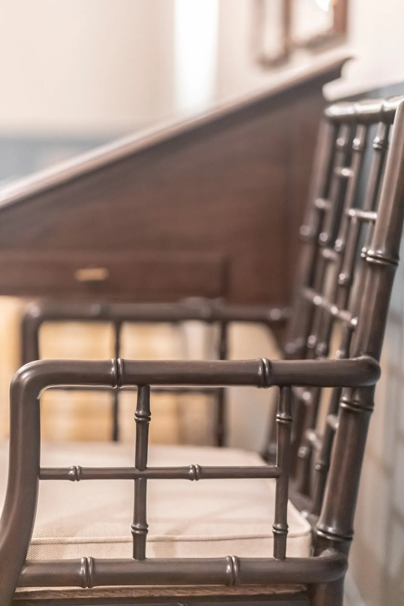 Senior living interior detail: dark faux bamboo lattice back chair at a wood desk