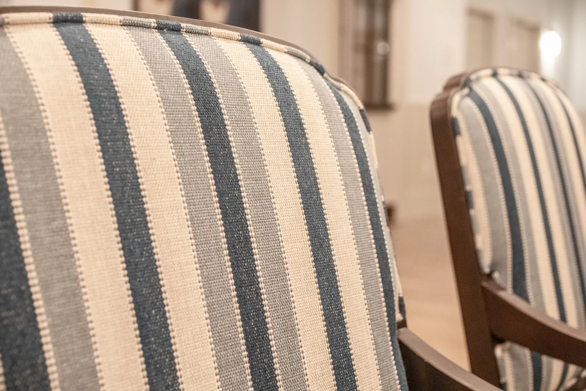 Senior living interior detail: blue and cream striped upholstery on dining chair backs