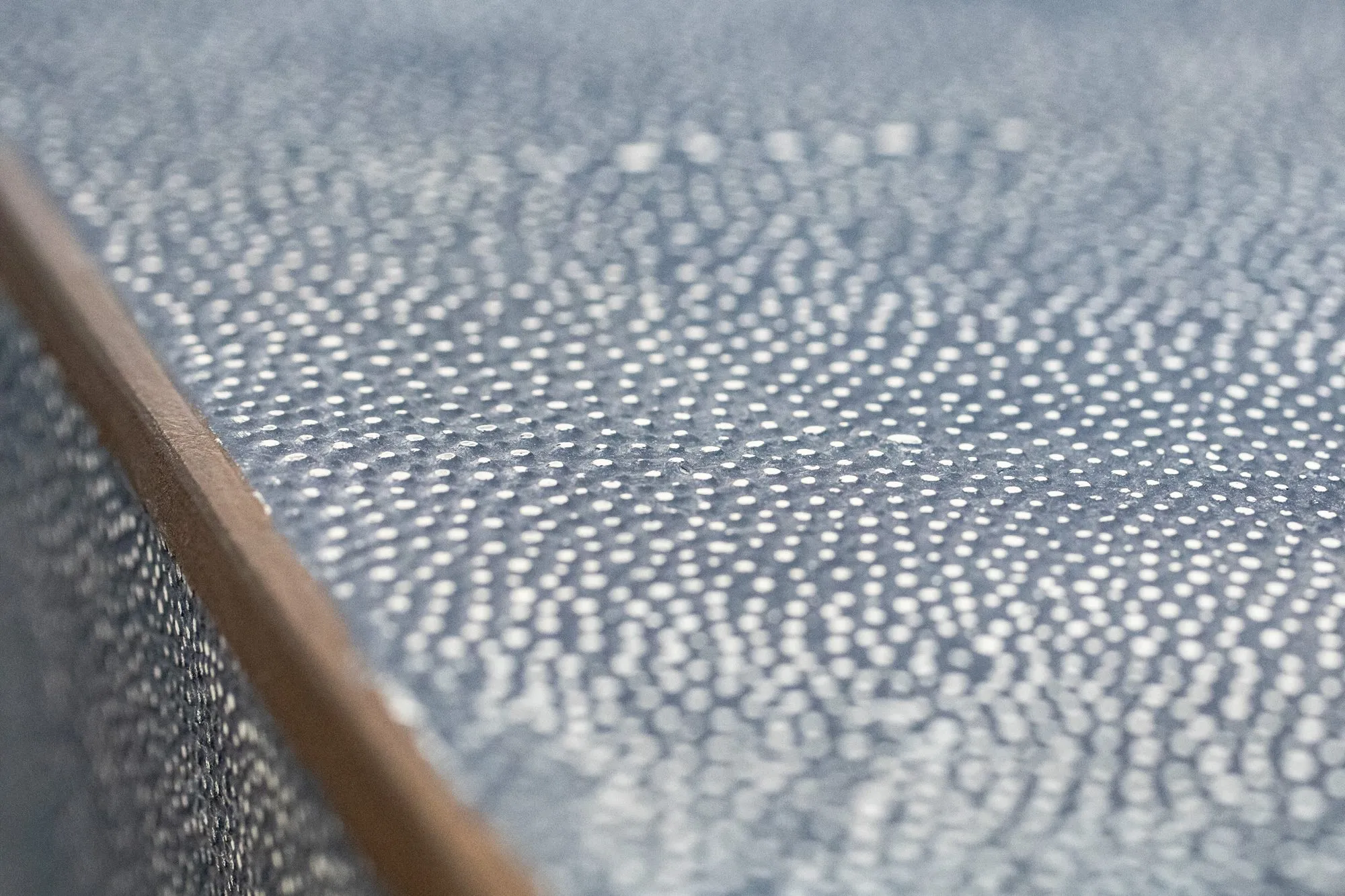 Senior living interior detail: blue shagreen textured surface with a bronze edge