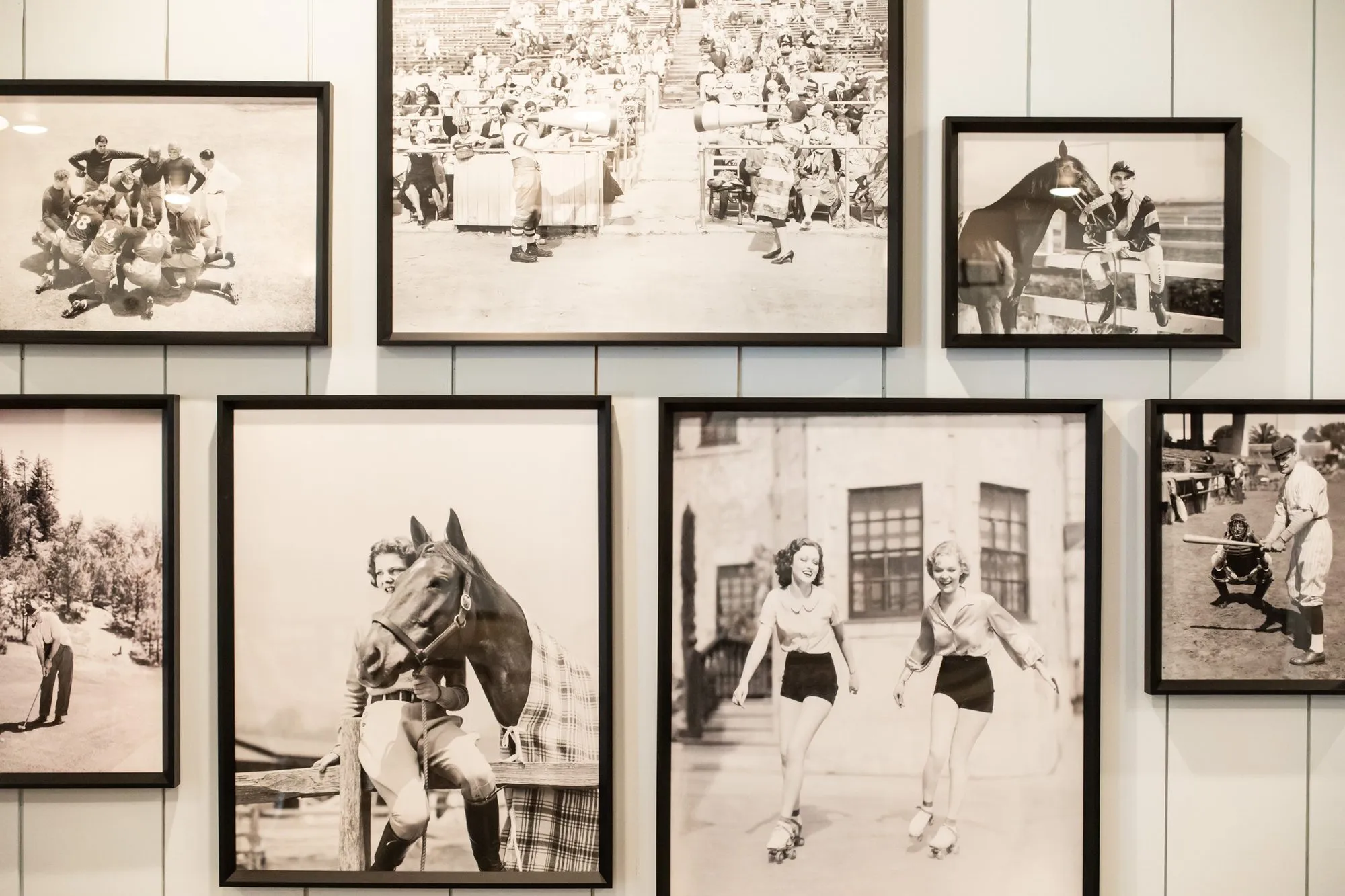 Senior living interior detail: gallery wall of black and white vintage photographs of sports, horses and roller skaters