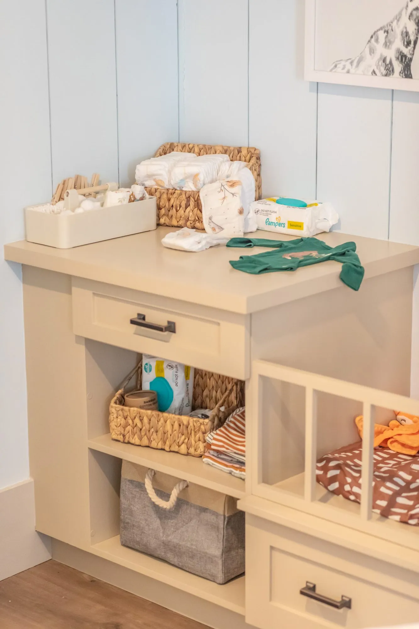 Senior living nursery changing station with baskets of diapers, a crib and storage bins