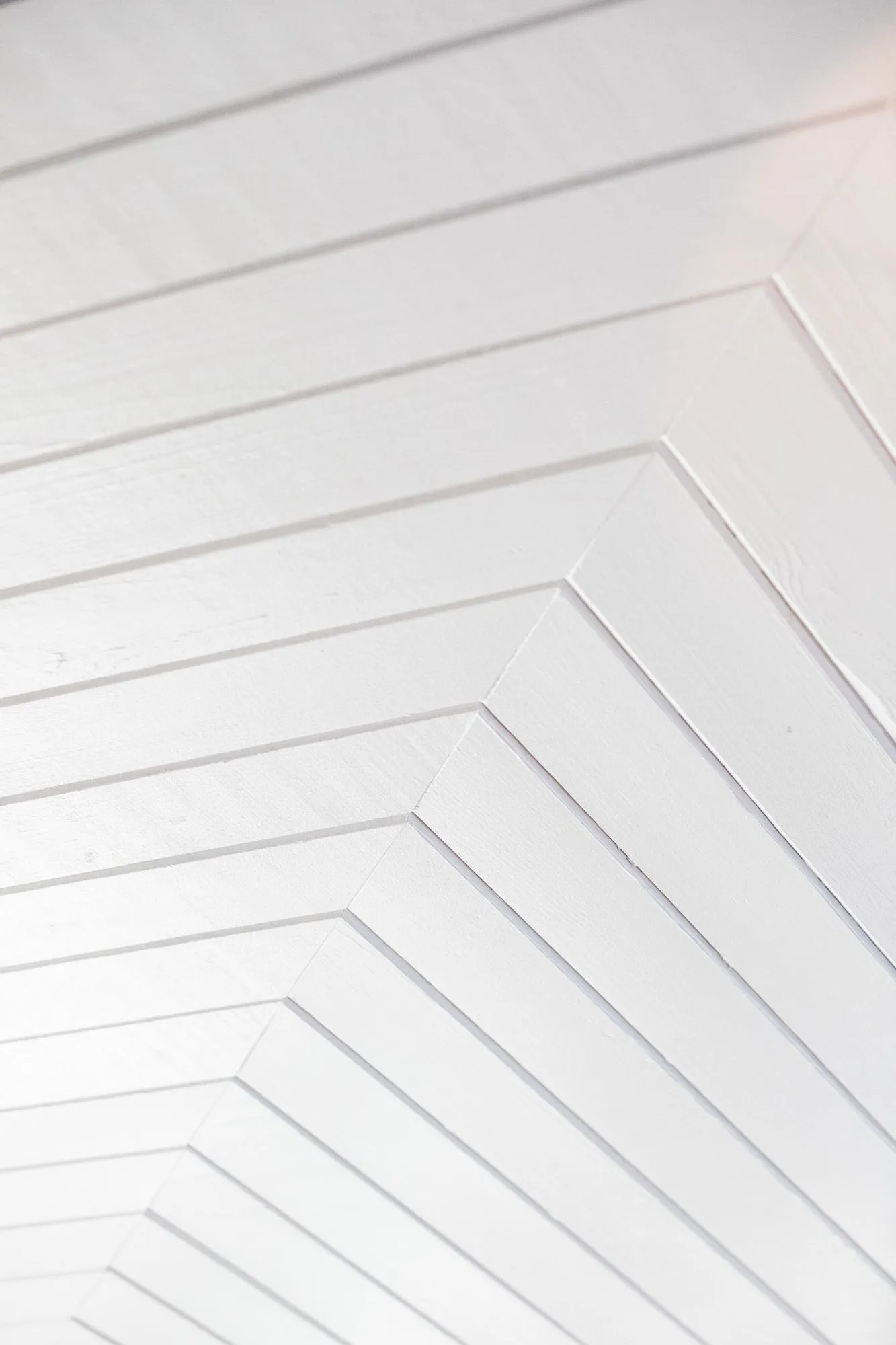 Senior living interior detail: white painted plank ceiling laid in a herringbone
