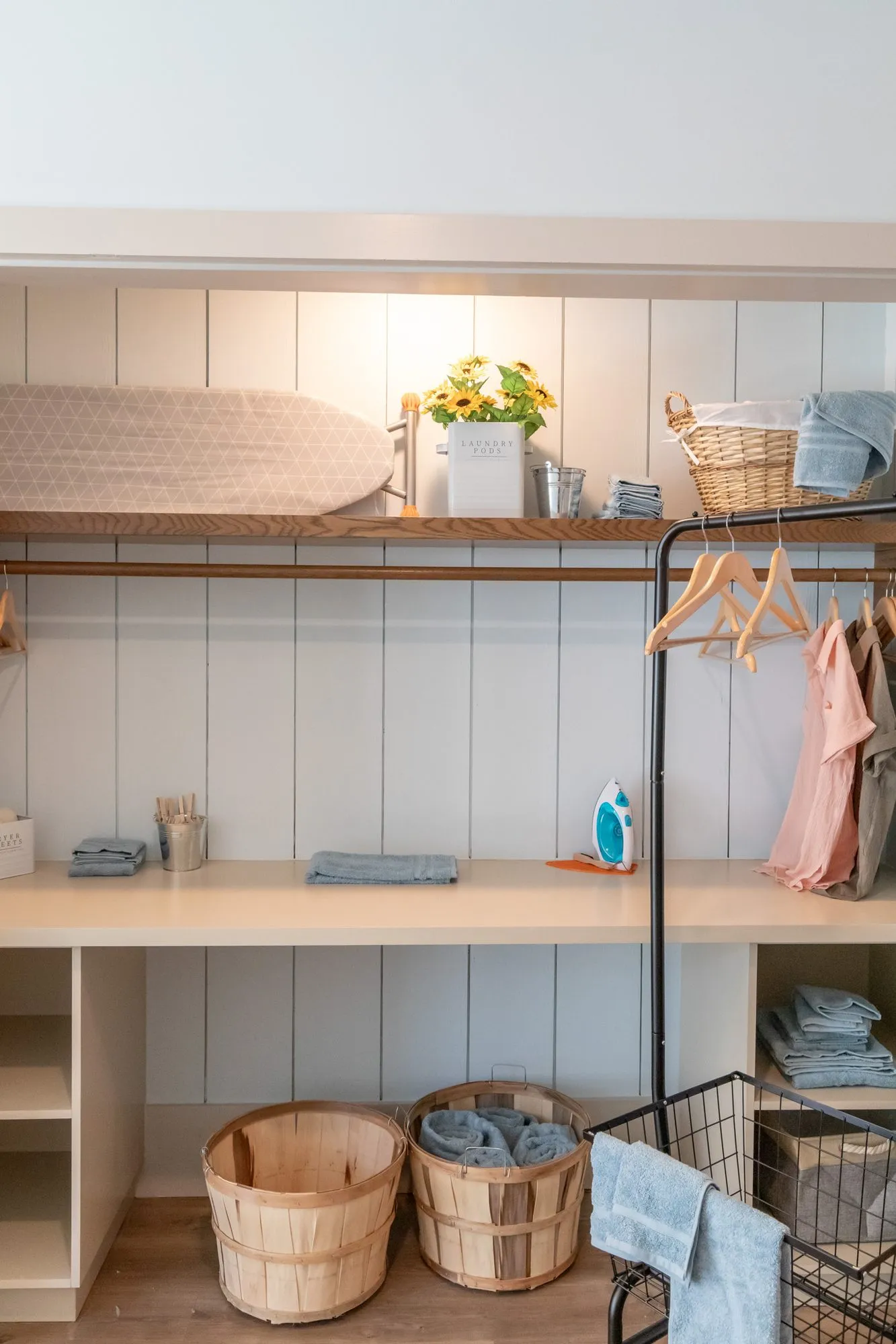 Senior living laundry nook with clothes on the rail, folded towels and bushel baskets below