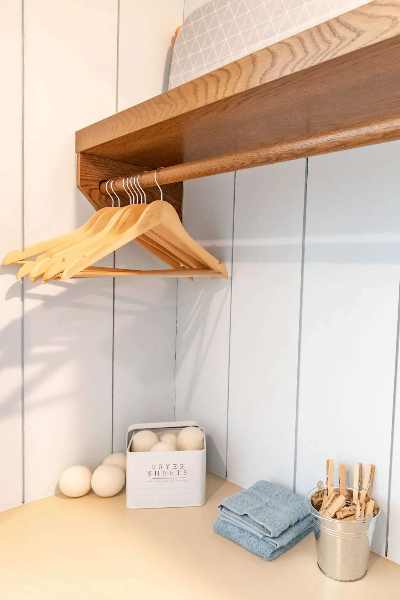 Senior living interior detail: wooden hangers on a rail above a counter with dryer balls, towels and clothespins