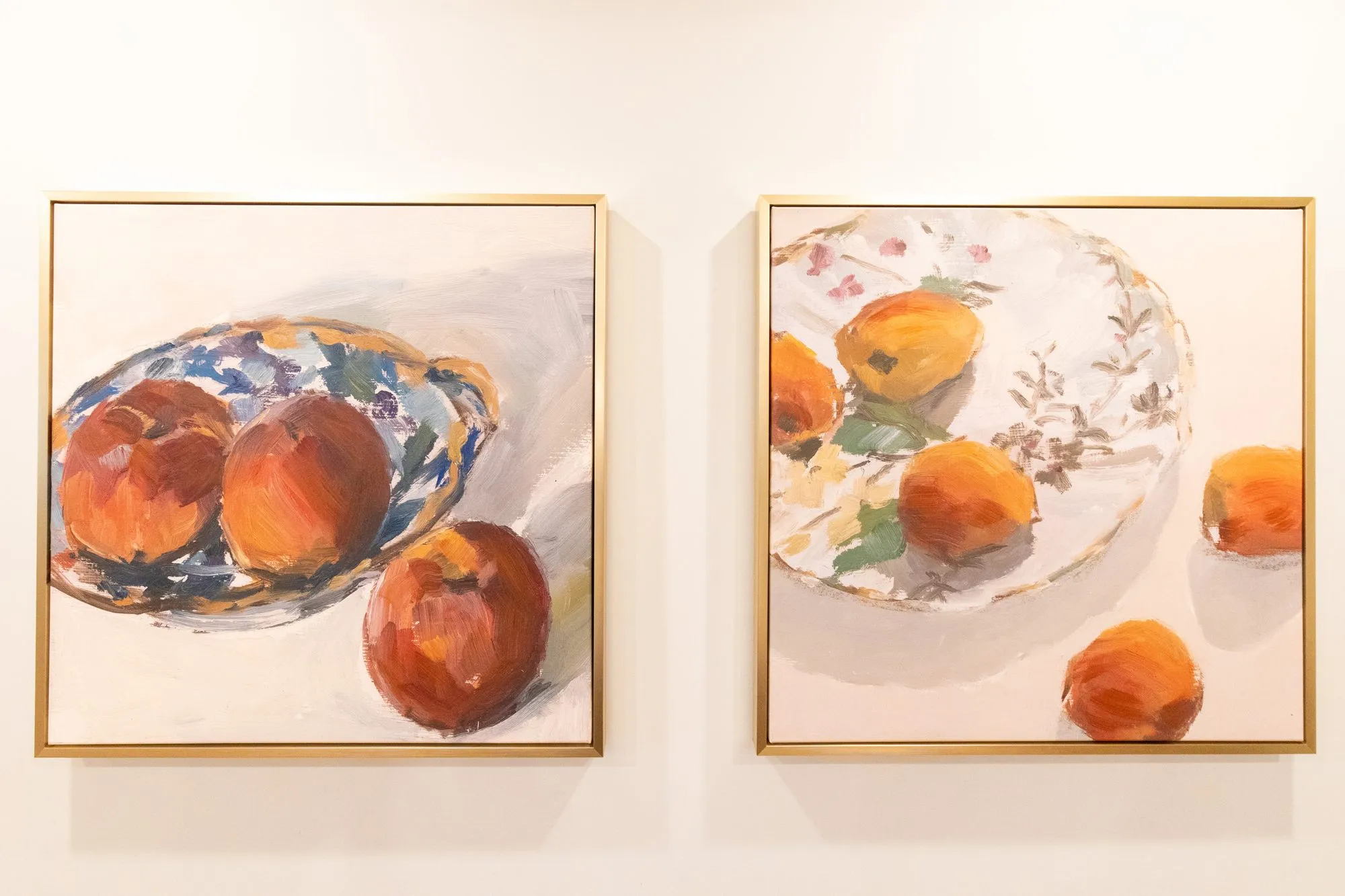 Senior living interior detail: two gold framed paintings of peaches on blue and white plates