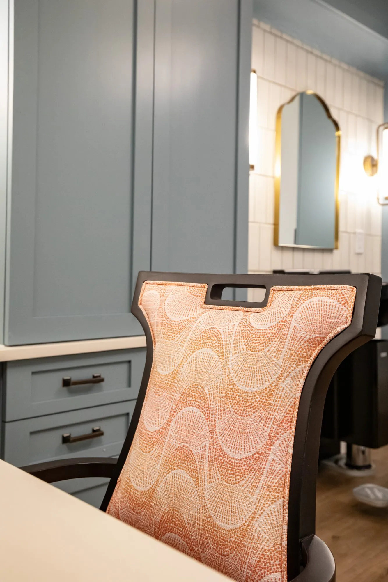 Senior living salon detail: coral wave pattern chair back at a salon vanity