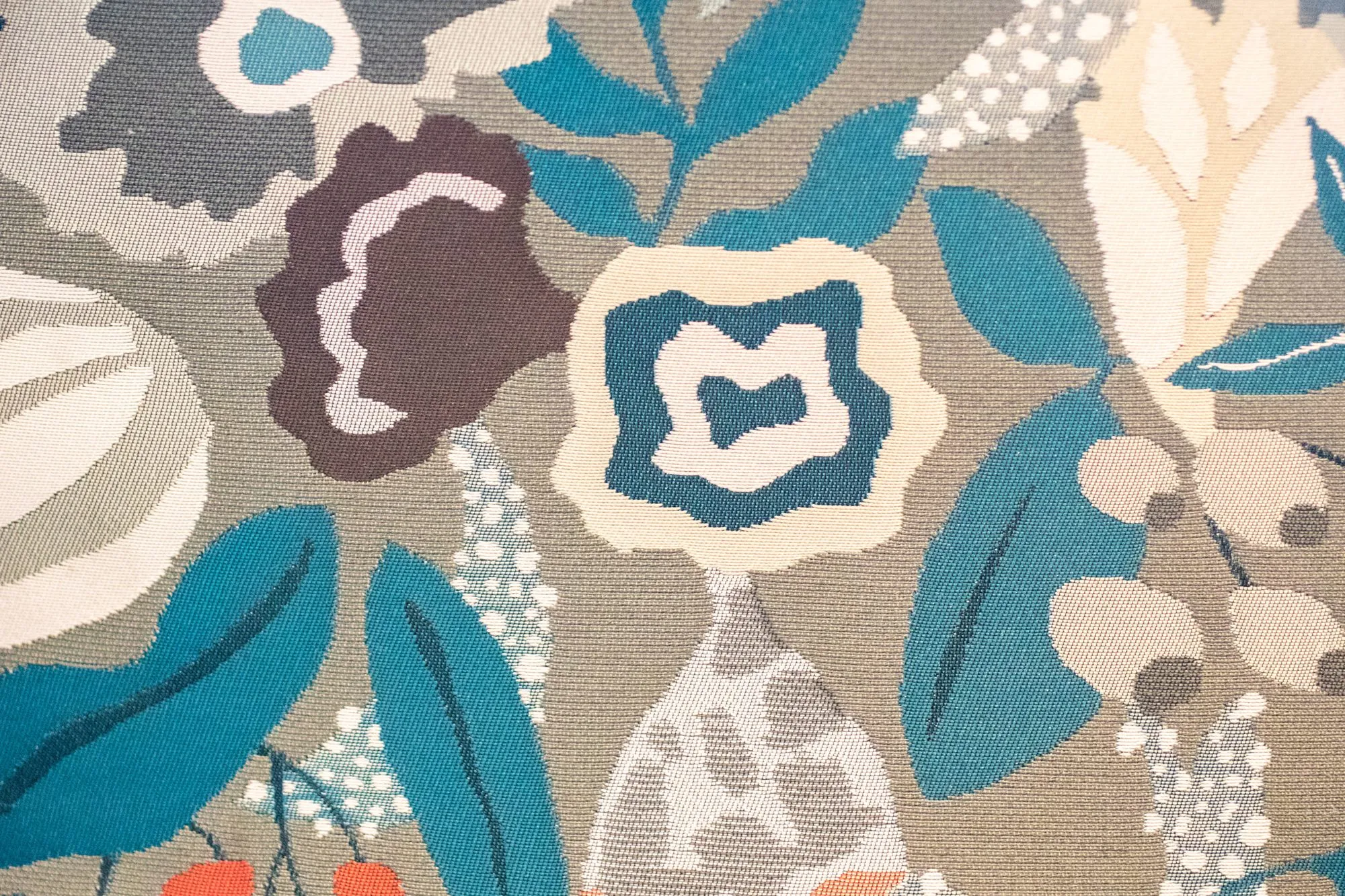 Senior living interior detail: large scale floral upholstery in teal, plum and cream on taupe