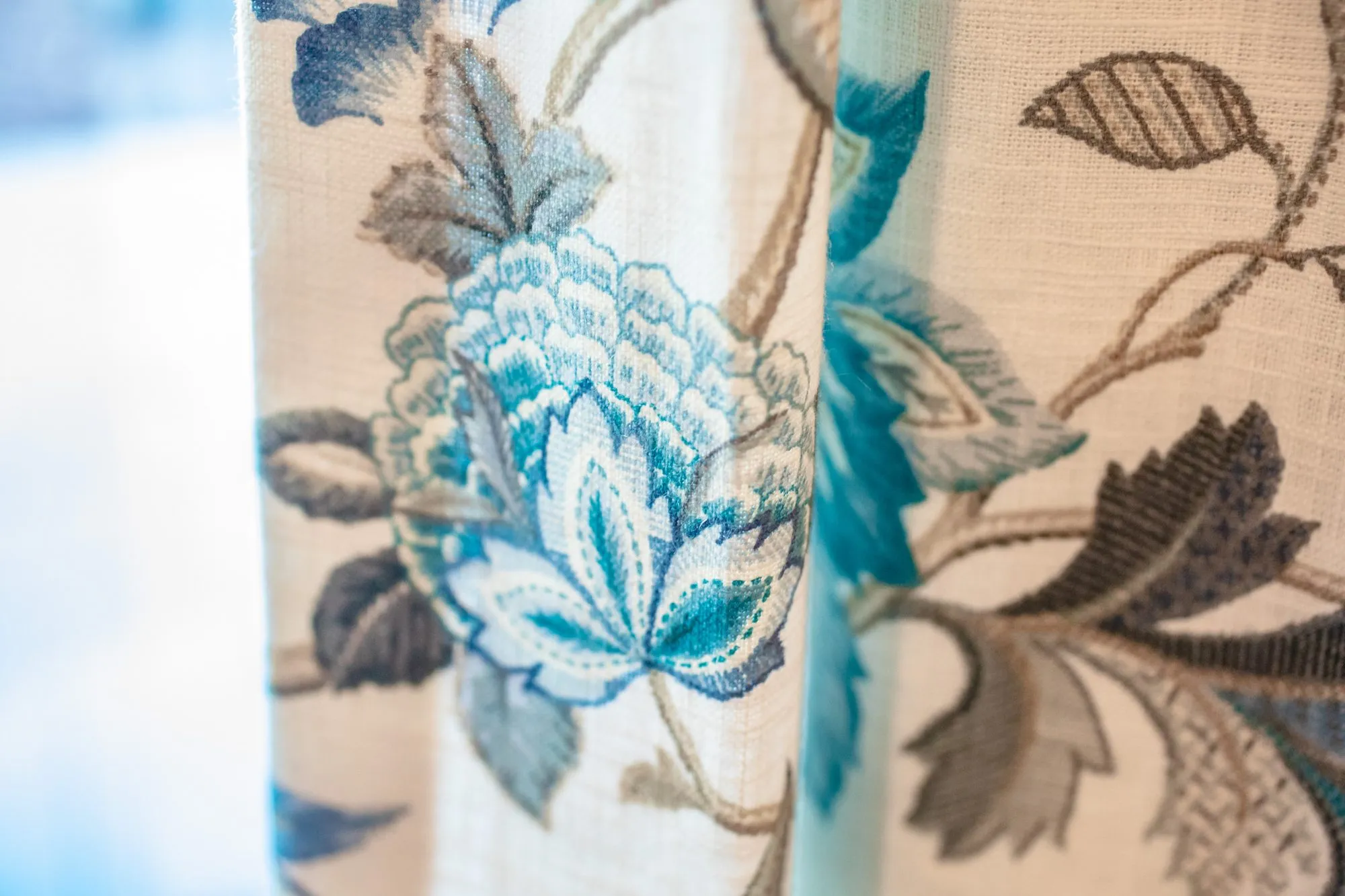 Senior living interior detail: cream drapery embroidered with teal and grey flowers