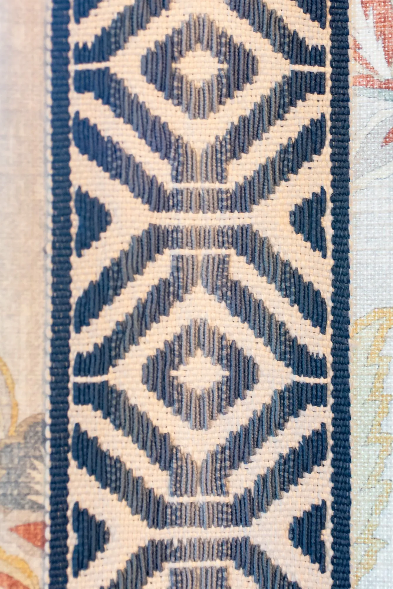 Senior living interior detail: navy and cream geometric drapery trim on floral fabric