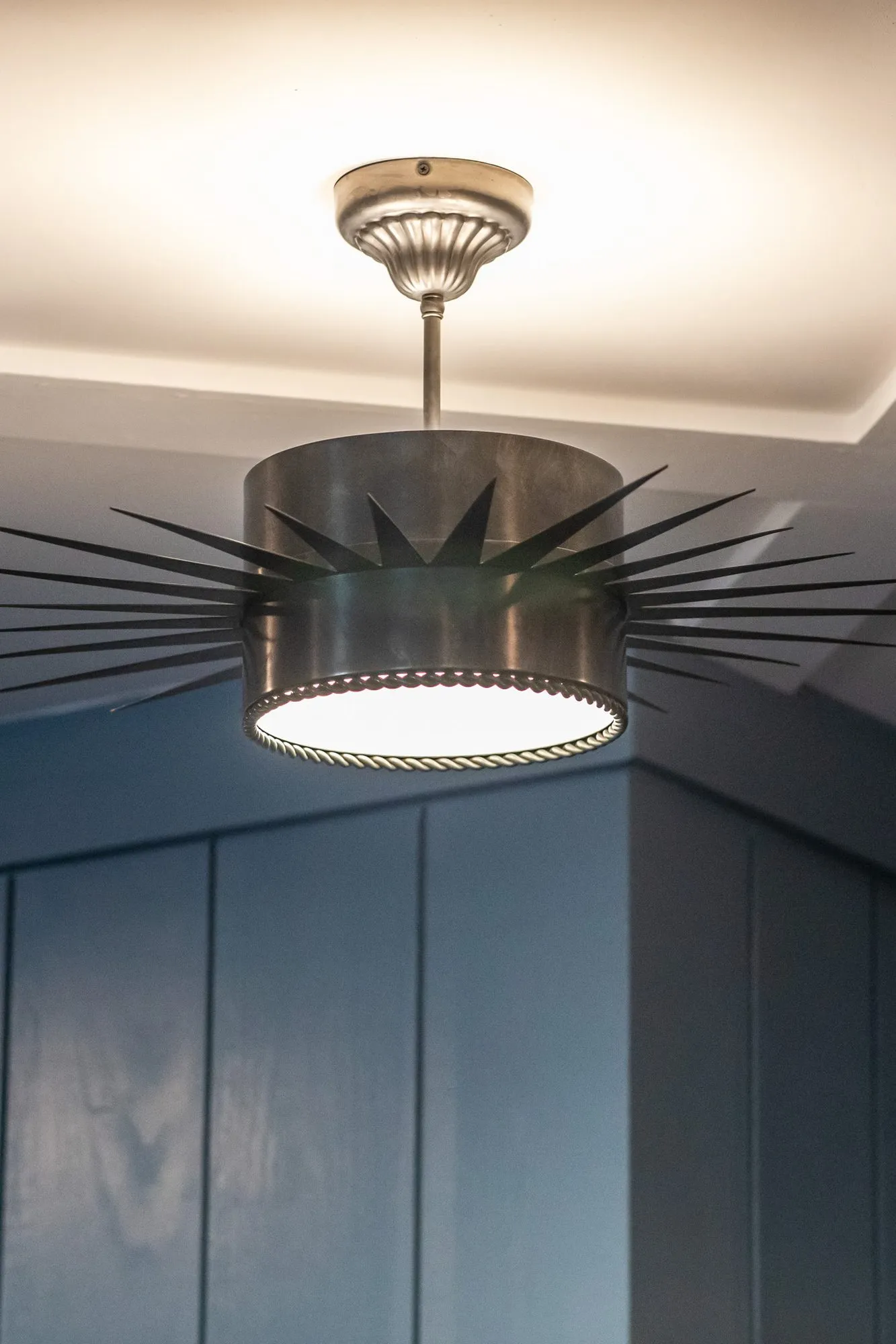 Senior living interior detail: black starburst ceiling light below a navy coffered ceiling