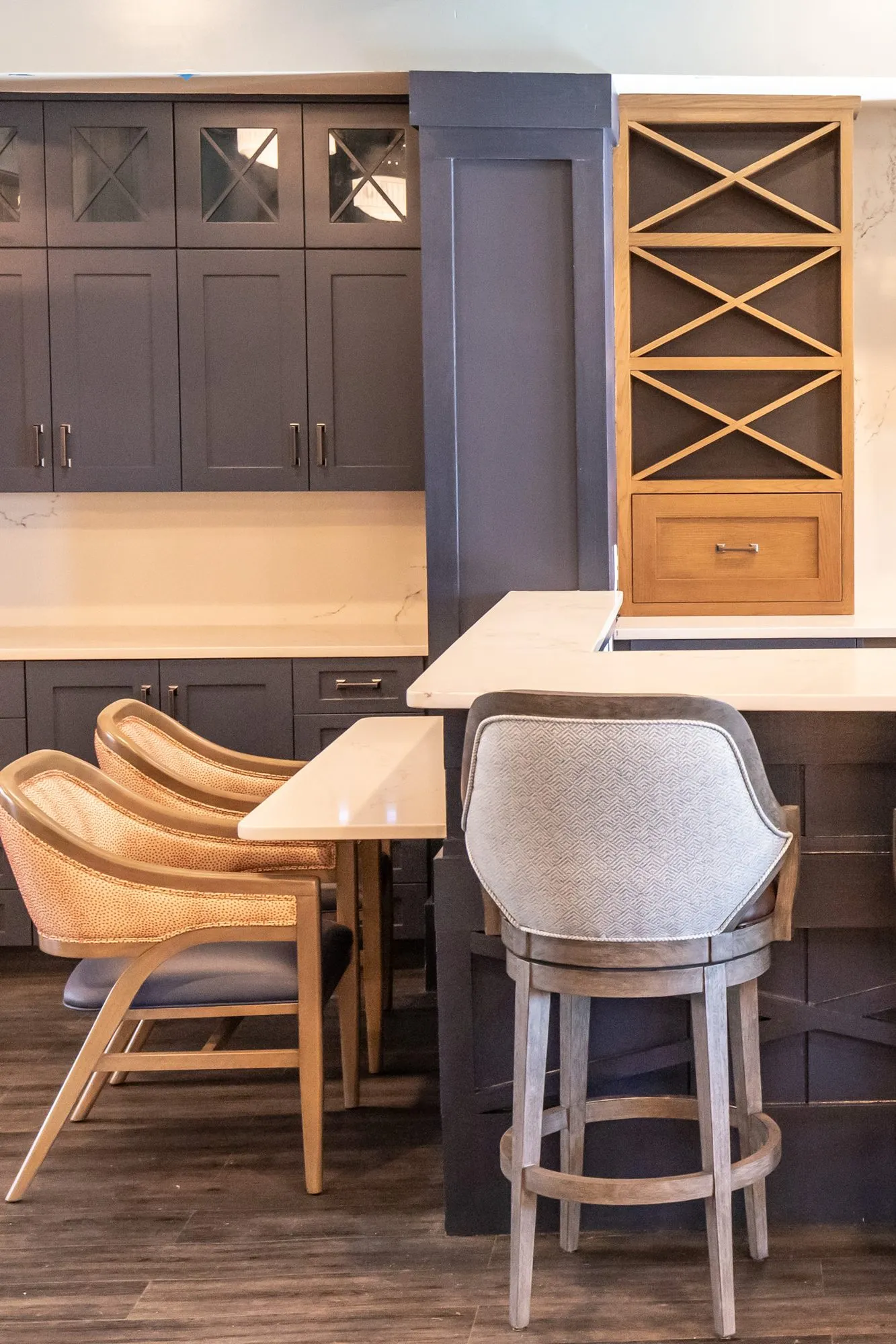 Senior living bar detail: coral dot chair and a herringbone barstool at a navy bar with an X wine rack