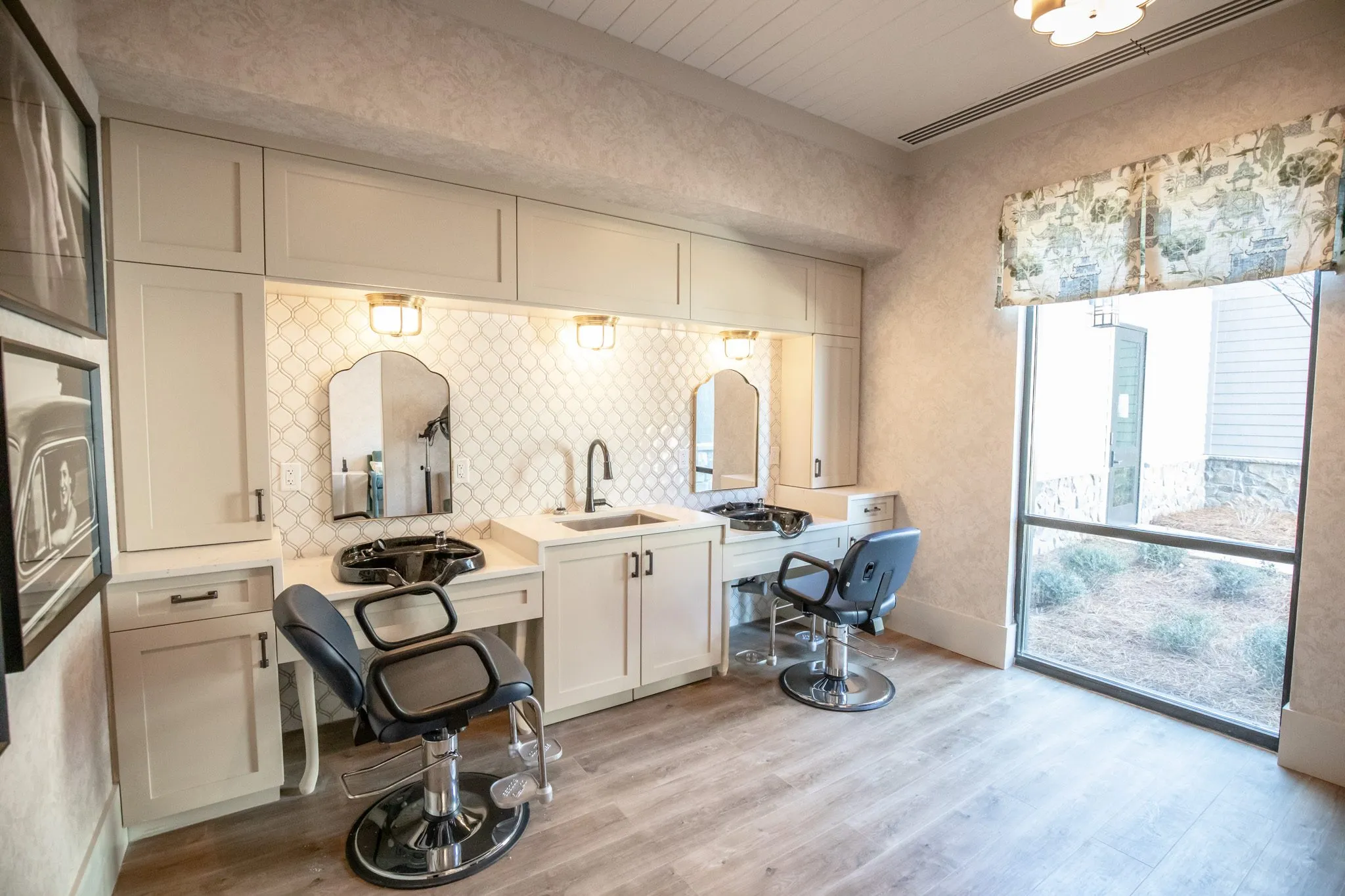 Senior living salon with two styling chairs at white vanities and arched mirrors on arabesque tile