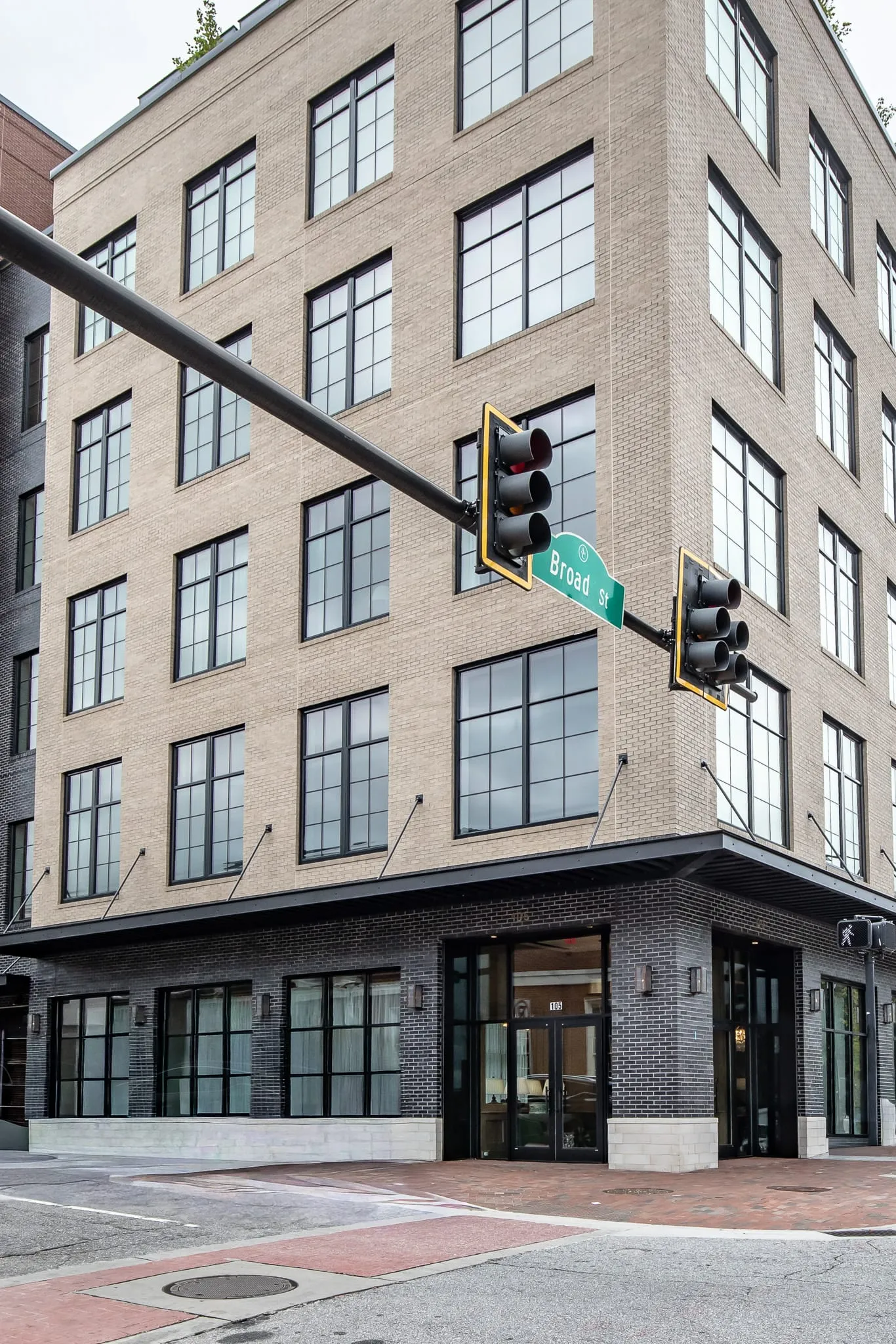 Private club building exterior: the Drake Building's brick facade with black storefront glazing