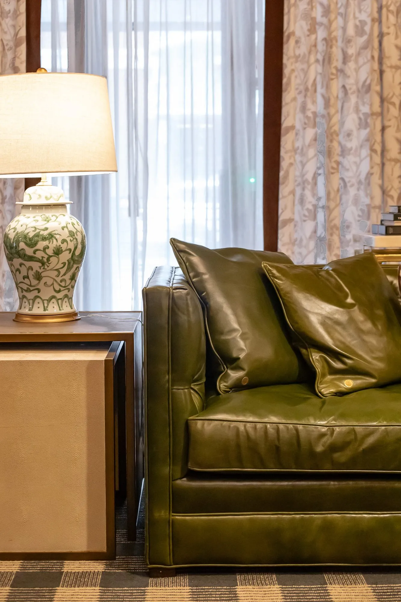 Private club interior detail: olive leather sofa beside a ginger jar lamp, interior design by Banko Design at The Rose Downtown Club, Athens, Georgia
