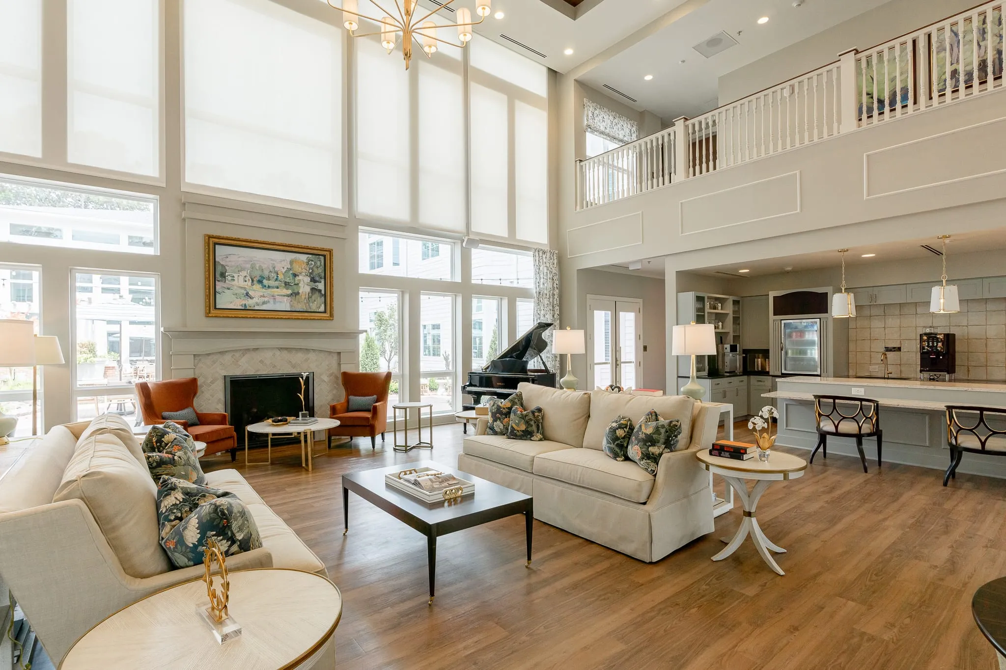 Senior living living room with a marble fireplace and grand piano below the second-floor balcony